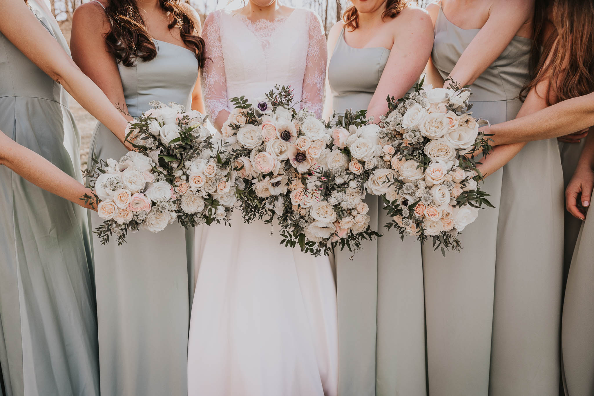 Bridesmaids holding the bouquets together